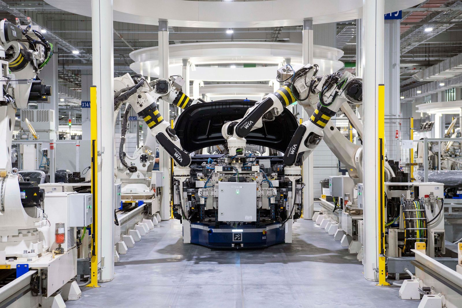 Industrial robot arms assembling an automotive body on a factory line